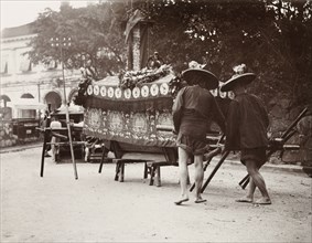 Pallbearers at a Chinese funeral. Two pallbearers prepare to carry a coffin on a wooden bier during