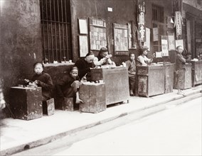 Cantonese seal carvers. A number of Cantonese seal carvers sit at their stalls, waiting for passing