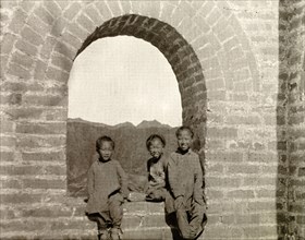 Children at a watchtower on the Great Wall of China. Three children pose for the camera in the