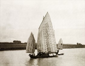 A junk transports salt on the Yangtze River. A Chinese junk with sails made from woven bamboo,