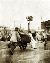 Handcart on a harbourside road in Seoul. A man pushes a handcart laden with luggage along a