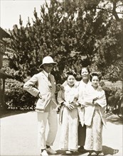 European man with two geisha and their 'okaa-san'. A European man poses outside a Japanese tea