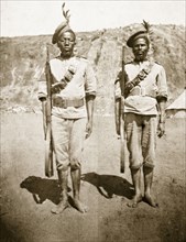 Armed Zulu policemen. Two armed Zulu policemen stand to attention, wearing feathered berets and