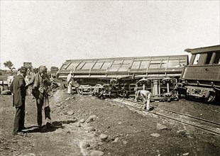 Derailed carriage on the Bulawayo line. A derailed railway carriage lies stricken on the Mafeking