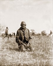 Portrait of a Matabele man. Portrait of an elderly Matabele (Ndebele) man, kneeling on the grass at
