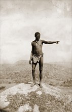 Matabele guide at the Matopos Hills. A Matabele (Ndebele) guide stands on the top of a granite