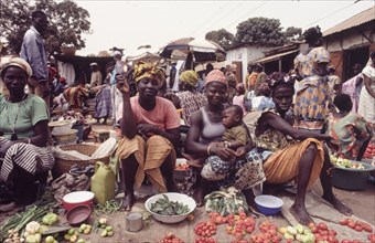Female street traders at Banjul market. Female traders sell fruit and vegetables at a bustling