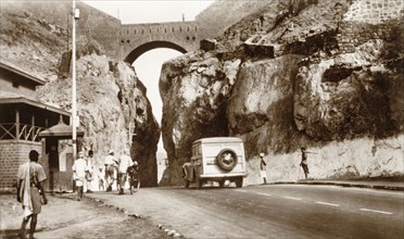The main pass between the crater and Steamer Point'. A motorcar drives along the pass linking