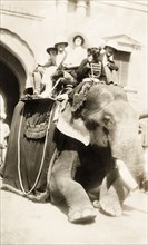 Europeans take an elephant ride, India. A group of smiling European people sit in a howdah on the