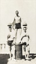 Hats off Brigadier Winthrop. Three European men pose for a comical photograph after a swim, wearing
