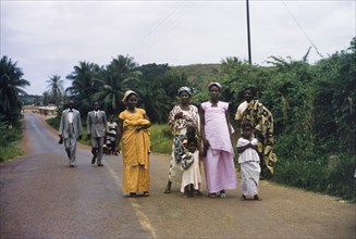 Churchgoers in Abandze. Families dressed in their Sunday best walk along a road to attend church in