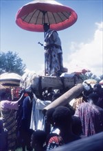 A Manya Krobo chief stands on a palanquin. A Manya Krobo chief stands up on a palanquin beneath a