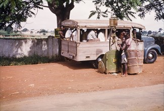 Roadside filling station. A petrol attendant fills a van from a British Petroleum (BP) pump at a