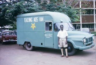 Mr Soah with a Teaching Aids Van. A smiling Government employee, Mr Soah, poses by a Teaching Aids