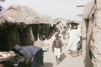 A marketplace in Kano. Thatched, open-fronted stalls line a busy marketplace in Kano. Kano,