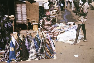 Cloth at a street market in Freetown. A female street trader sells rolls of patterned cloth on a