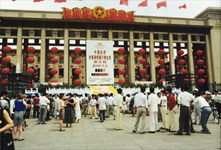Celebrating the handover of Hong Kong. A crowd of people gather in a piazza outside a building