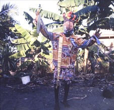 A Carib dancer in Belize. A Carib dancer performs a dance wearing a colourful costume, a painted