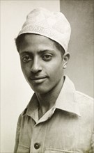 Muslim man wearing a kufi. Portrait of a young Muslim man wearing an embroidered kufi (cap). Lamu,