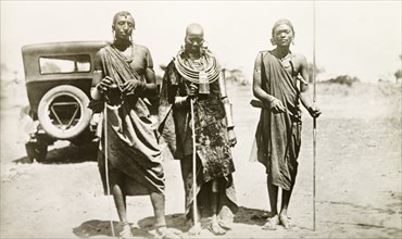 Maasai portrait. Portrait of two Maasai men and a Maasai woman. They stand in a line on a rural