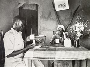 A Kikuyu couple in a Western-style home. A Kikuyu employee of the government's Agricultural