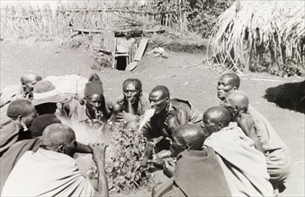 Kikuyu good fortune ceremony. A group of Kikuyu men gather in a circle, performing a ceremony to
