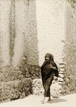 Woman in traditional Muslim dress. A woman wearing a traditional Muslim burqa walks along a street