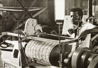 Craftsman operating a lathe, Ghana. A craftsman operates a wood-turning lathe to shape a section of