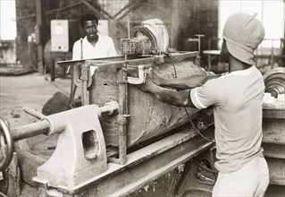Craftsman operating a lathe, Ghana. A craftsman operates a wood-turning lathe to shape a section of