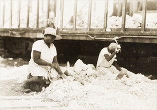 Women breaking up rocks, Jamaica. Two female labourers sit amidst a pile of rocks, breaking large