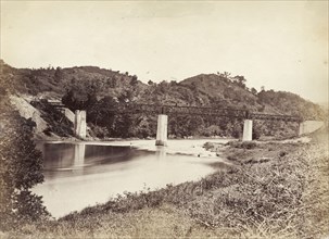 Railway bridge in Ceylon. An iron girder railway bridge runs across a river in Ceylon. Ceylon (Sri
