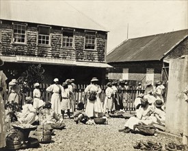 Outside the 'Standard Rum Shop'. Traders sell their wares from baskets outside the 'Standard Rum
