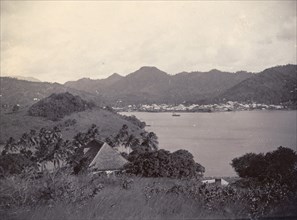 A bay in St Lucia. A coastal settlement nestles in the foothills of mountains across a bay in St
