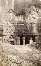 An entrance to the Ajanta caves. Religious figures are carved into the rockface outside a pillared
