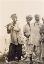 Musician playing a 'satara'. A musician plays a 'satara' (Indian dual flute) for a small audience