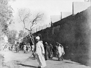 Street scene in Sukkur. People walk to and fro along a wide street in Sukkur. Sukkur, Sindh, India