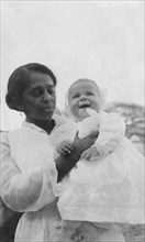 Indian ayah with Betty. An Indian ayah (nursemaid) called Nannie holds up a smiling four month old
