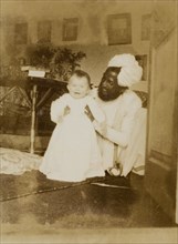 Indian house servant with baby Margaret. An Indian house servant, Hyder Khan, poses playfully with