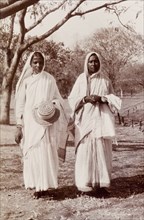 Indian women wearing saris. Portrait of two Indian women wearing traditional saris. One holds a