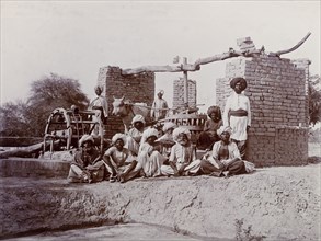 A bullock-driven water wheel, India. A group of Indian labourers pose for an outdoor portrait