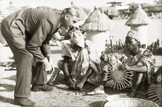 A basket-weaving demonstration. A European man visiting Kaduna Children's Village with Queen