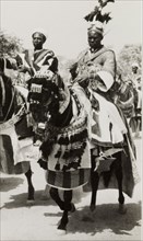 Nigerian chief riding a caparisoned horse. A Nigerian chief wearing an elaborate feathered