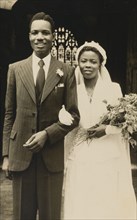 Titus and Oredola. A newlywed couple, Titus and Oredola, pose on the steps outside Freetown