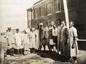 Railway servants beside a private carriage. African railway servants pose for a group portrait