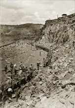 Rail carts at the Premier Diamond Mine. African labourers load rail carts full of rubble at the