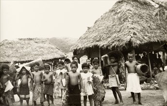 Samoan schoolchildren . A group of Samoan schoolchildren carry woven mats on their return home from