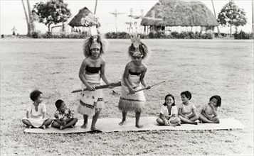 Samoan women perform a 'siva'. Two young Samoan women perform a 'siva' (dance) on a woven mat,