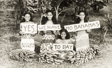 Yes, we have no bananas today'. Four young Samoan women kneel on a patch of grass behind several