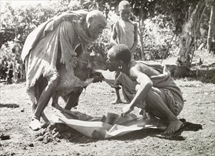 Kikuyu purification ceremony. A Kikuyu man takes part in a purification ceremony, drinking a witch