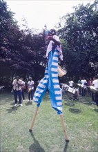 Stilt walker at the Caribbean Music Village. A stilt walker dressed in a blue and white striped
